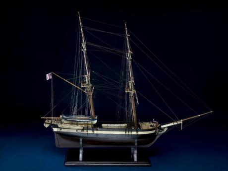 Photo of a wooden ship model against a dark backdrop